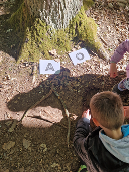 Kinder lernen Buchstaben im Wald