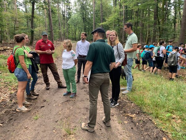 Klimaschutzministerin Katrin Eder, SDW-Vorsitzende Isabel Mackensen-Geis (MdB) und Herrn Vincent Meakins von der Sparda-Bank Süd West eG als Sponsor machen sich ein Bild von den Wald-Jugendspielen